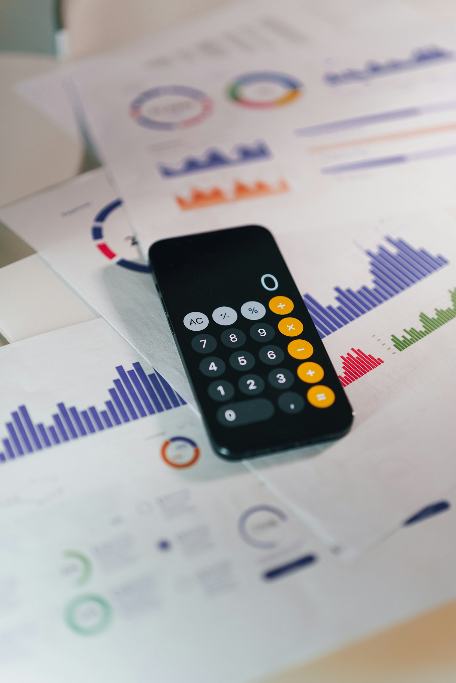 Смартфон з калькулятором на фінансових документах